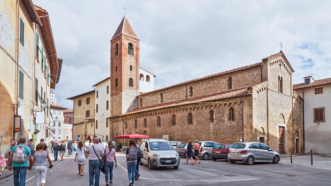 Tourists approaching San Sisto Church in Cortevecchia, Pisa.