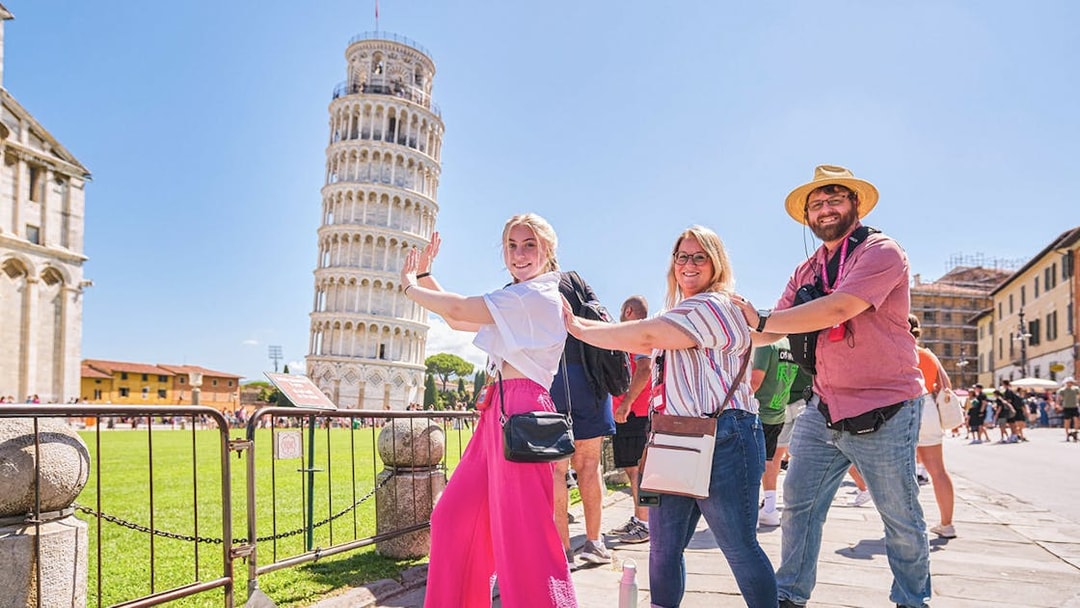 Visitors posing creatively with the Leaning Tower of Pisa in Italy.