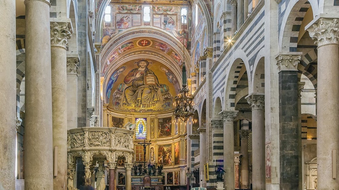 Interior view of Pisa Cathedral, Italy, featuring ornate frescoes and columns.
