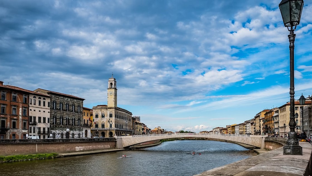 River Arno with historic buildings and bridge in Pisa, Italy.