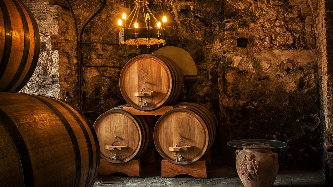 Wine barrels in a rustic Tuscan cellar on the Tuscany Wine and Olive Oil Trail tour.