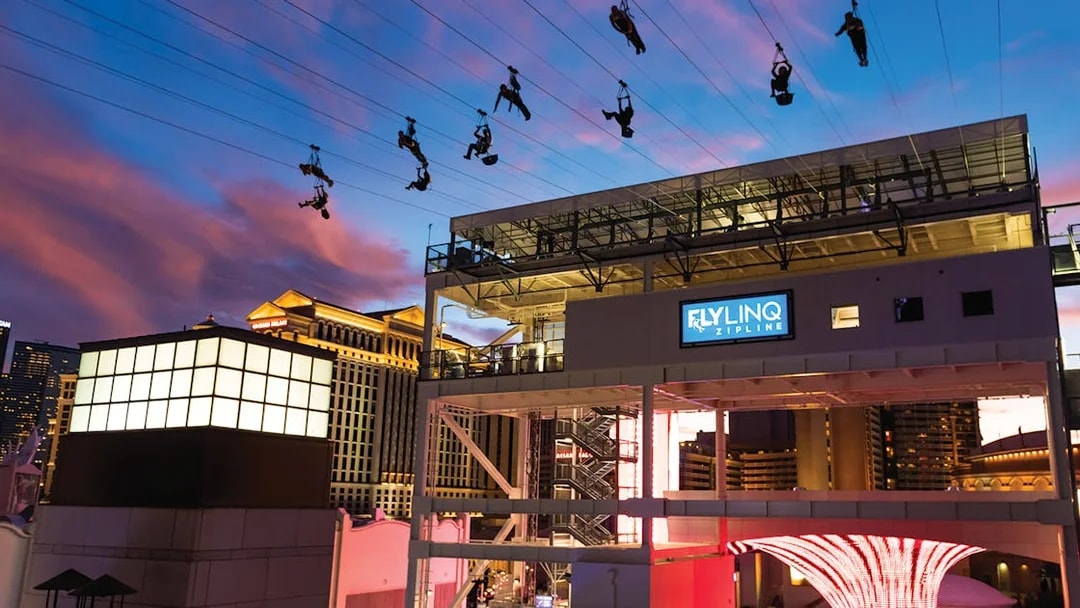 Fly LINQ Zipline riders above Las Vegas Strip at sunset.