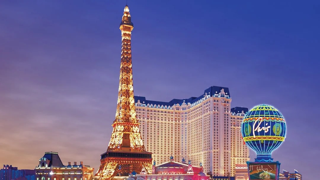Eiffel Tower replica and Paris Hotel on Las Vegas Boulevard at dusk.