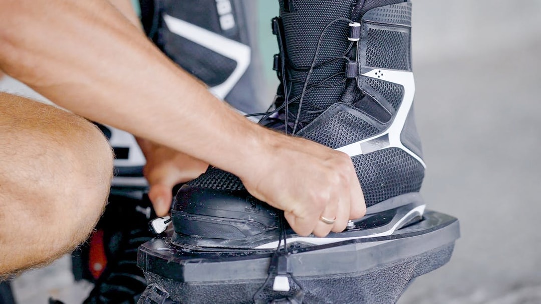 Man securing flyboarding boots for adventure in Dubai.