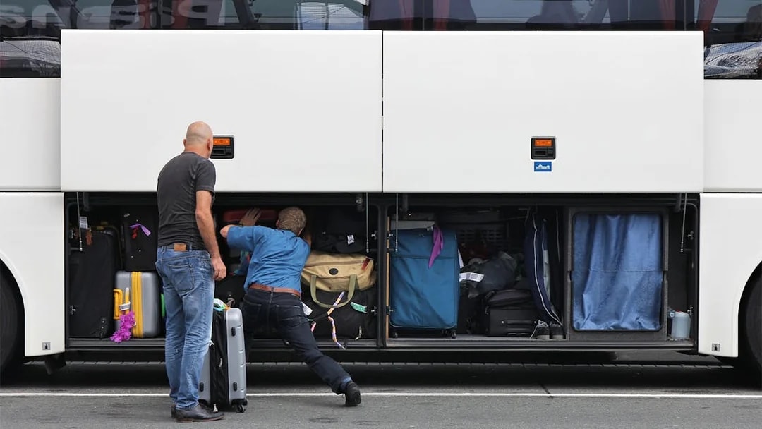 Passengers loading luggage into a bus compartment for Roma Linee one-way tickets from Rome Fiumicino Airport.