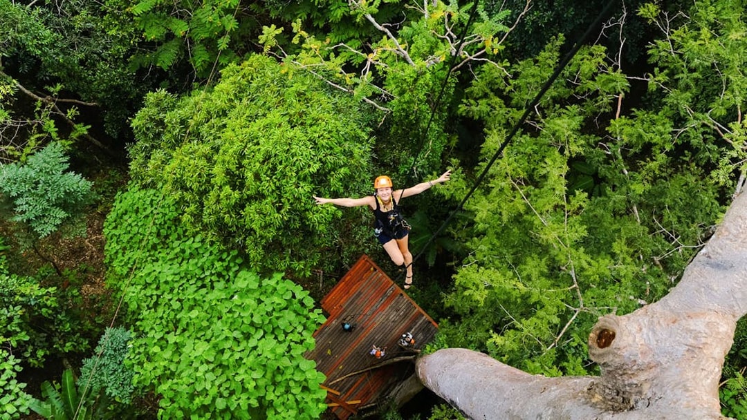 Person ziplining through lush forest canopy at Flying Hanuman, Phuket.