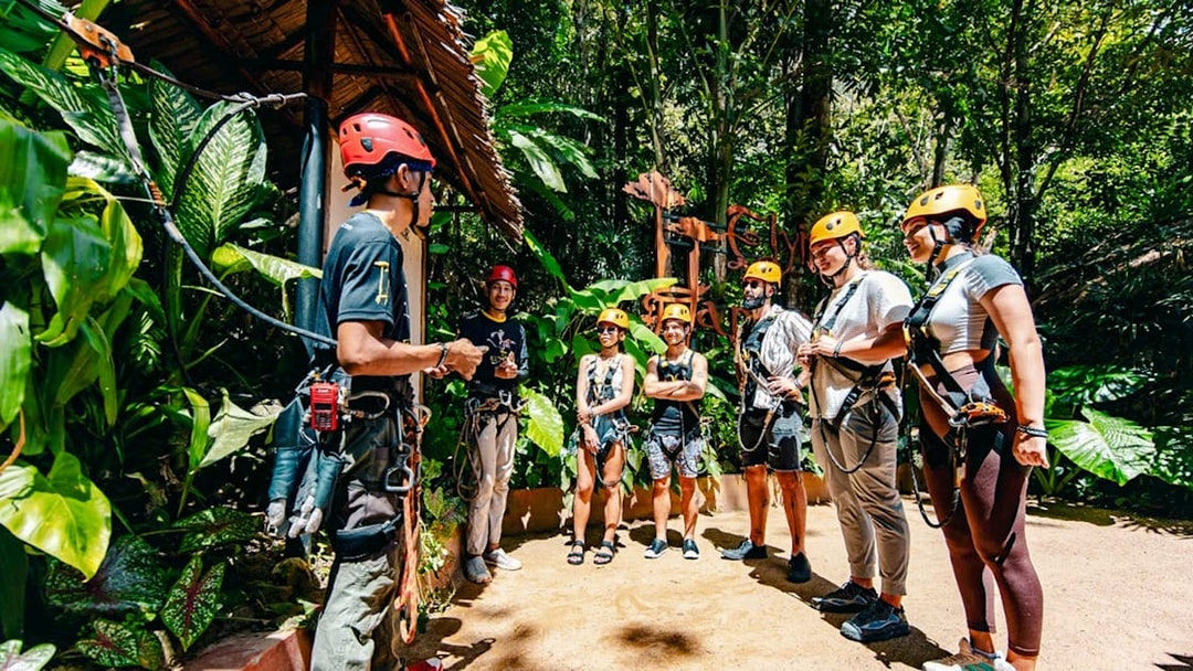 Group preparing for zipline adventure at Flying Hanuman, Phuket, wearing safety gear.