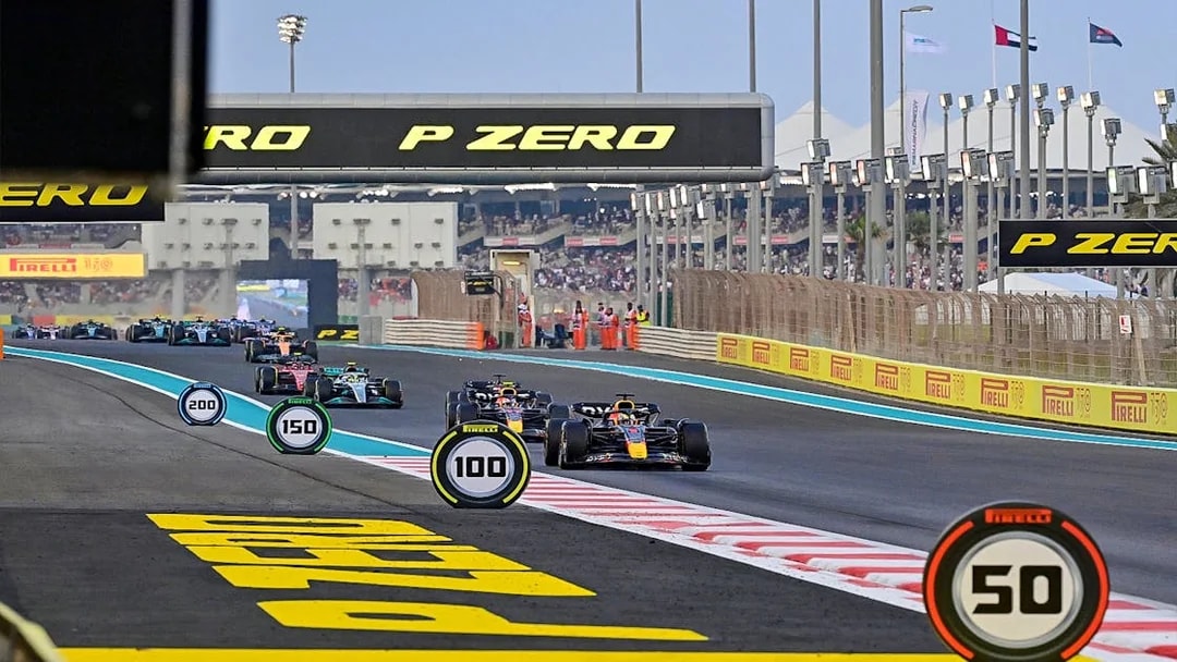 Formula 1 cars racing on Yas Marina Circuit during Abu Dhabi Grand Prix.