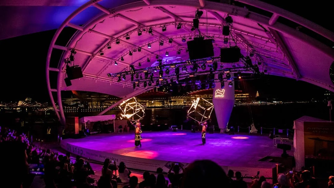 Performers with fire props on stage at Esplanade Outdoor Theatre, Singapore, during Formula 1 Grand Prix 2025.