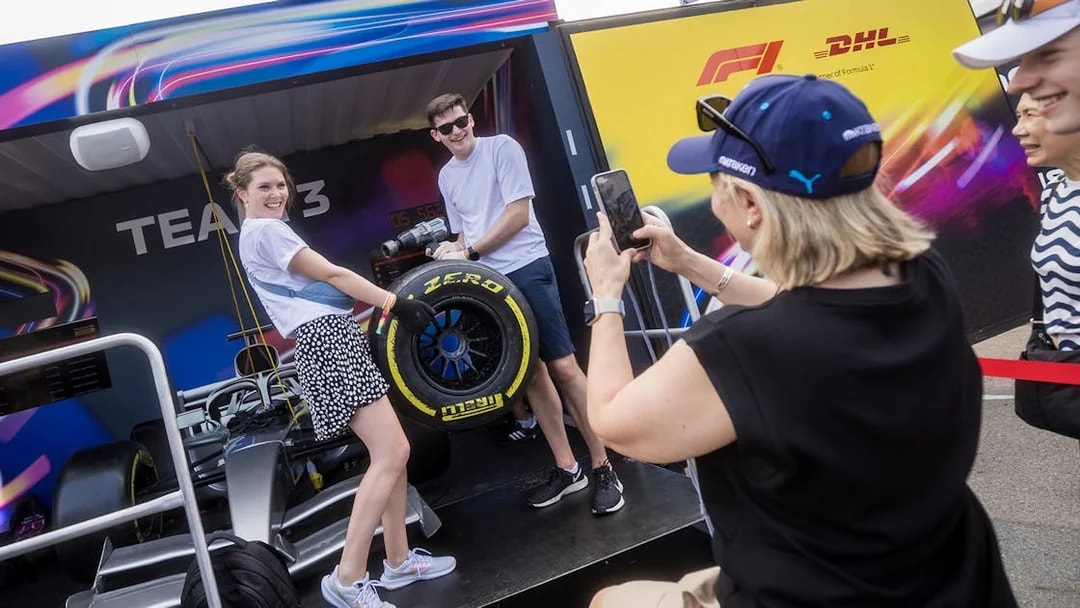 Participants in a pit stop challenge at F1 Singapore, changing a tire on a race car.