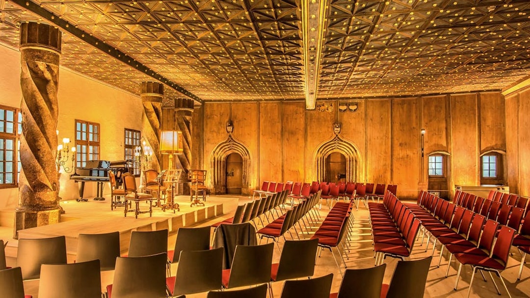 Fortress Hohensalzburg concert hall with empty seats and stage in Salzburg, Austria.