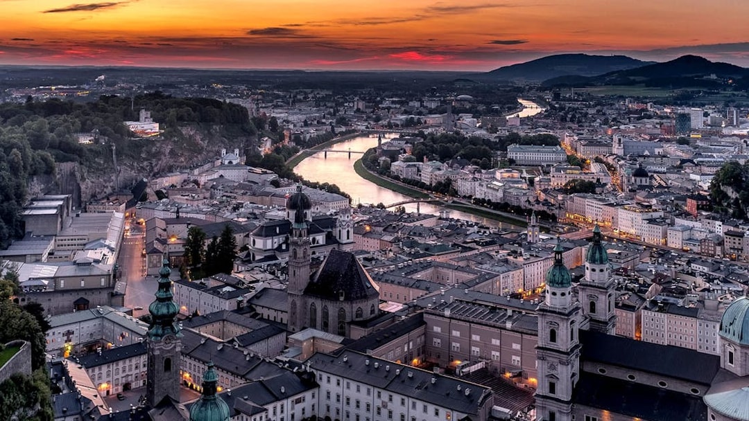 Aerial view of Salzburg at sunset with Fortress Hohensalzburg and Salzach River.