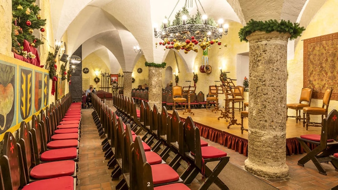 Fortress Hohensalzburg concert hall decorated for Christmas Advent event with chairs and stage.