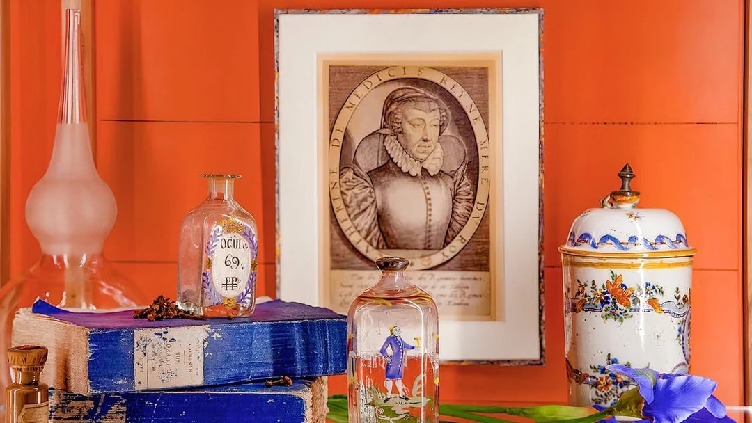 Fragonard Perfume Museum display with vintage bottles, portrait, and decorative jar.