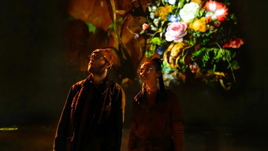 Visitors viewing digital floral art at Frameless London exhibition.