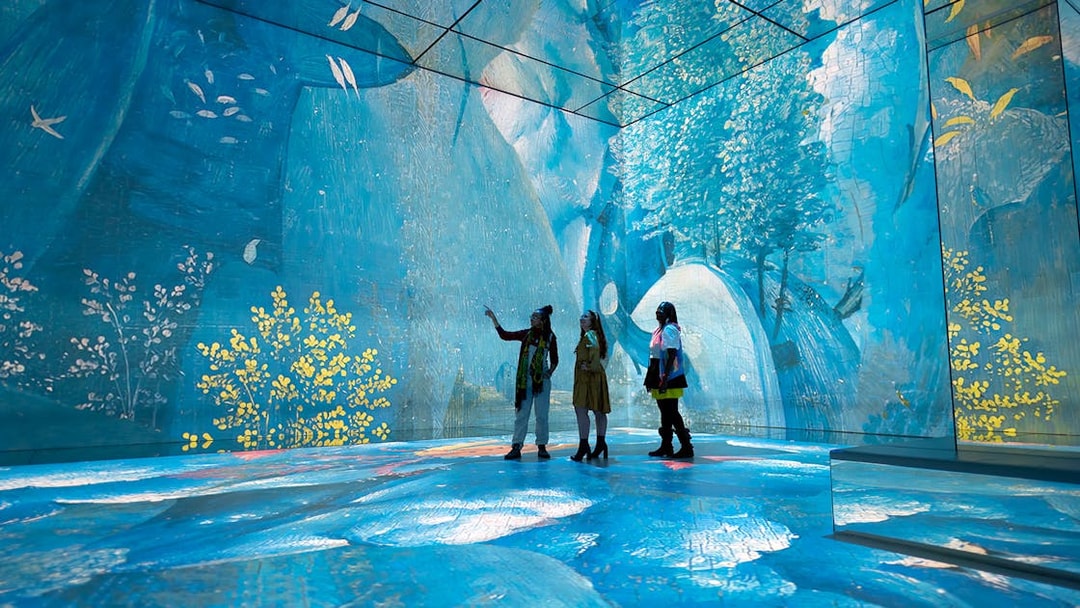 Visitors exploring immersive digital art at Frameless London exhibit.