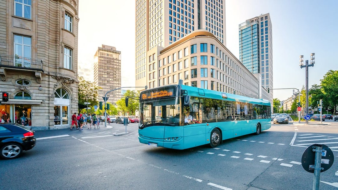 City bus on a street in Frankfurt am Main with modern buildings in the background.
