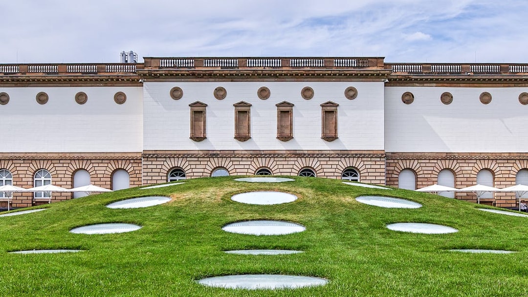 Frankfurt museum building with unique circular skylights on grassy hill.