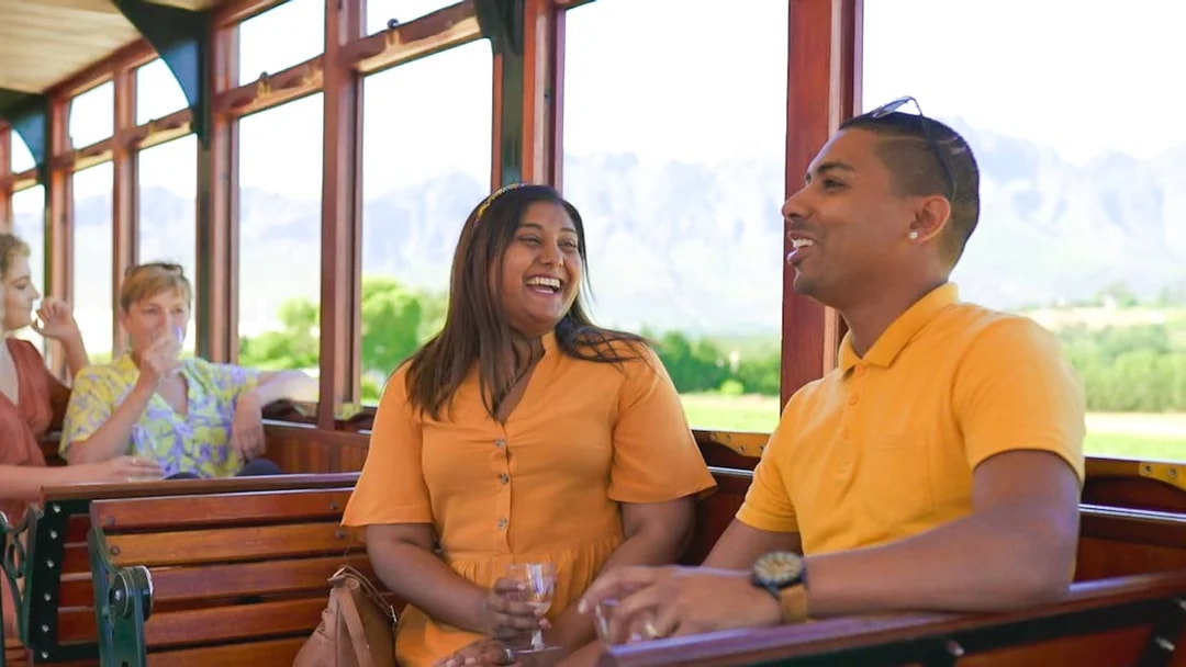Couple enjoying Franschhoek Wine Tram Xplorer Tour, Cape Town.