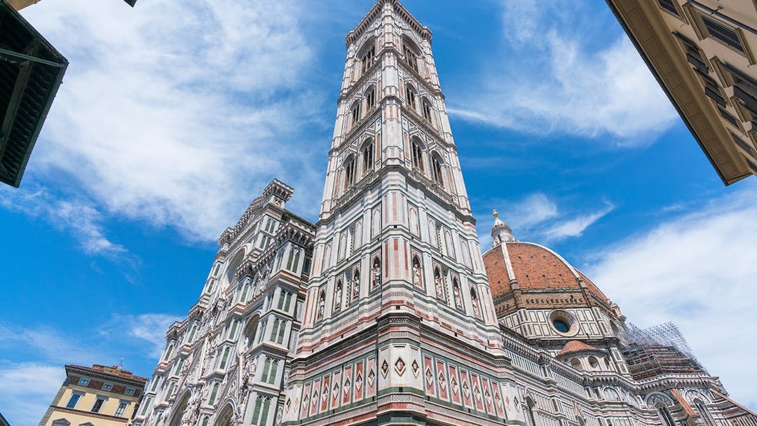 Giotto's Bell Tower beside Florence Cathedral under blue sky, part of Florence in a Day tour.