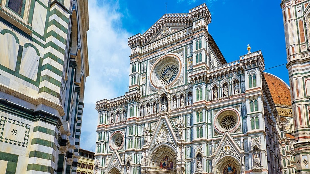 Facade of Florence Cathedral with intricate marble design and rose window.