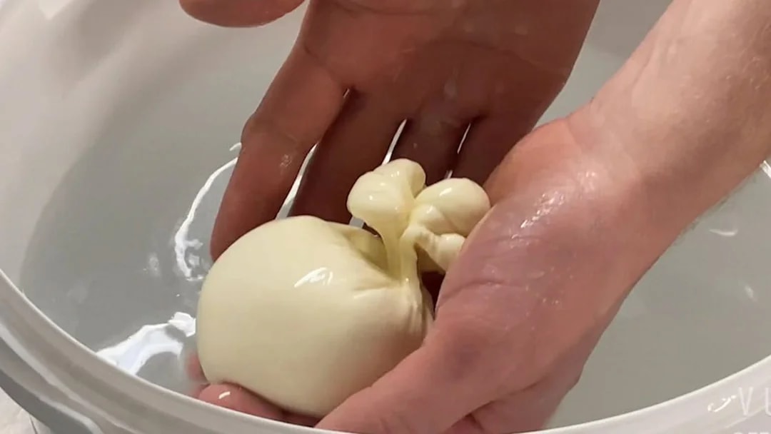 Person crafting burrata cheese at Cheese Museum, Paris, France.