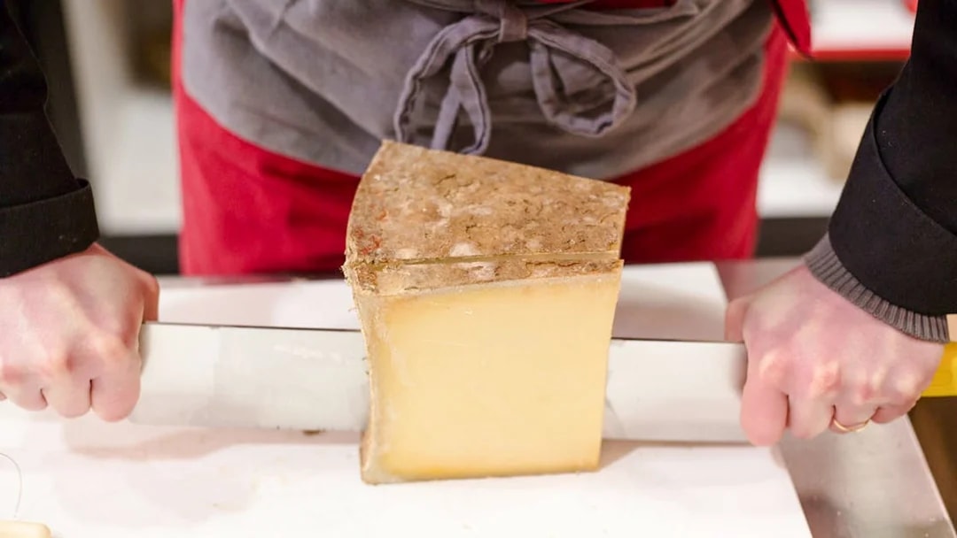 Cutting cheese at the Cheese Museum in Paris, France.