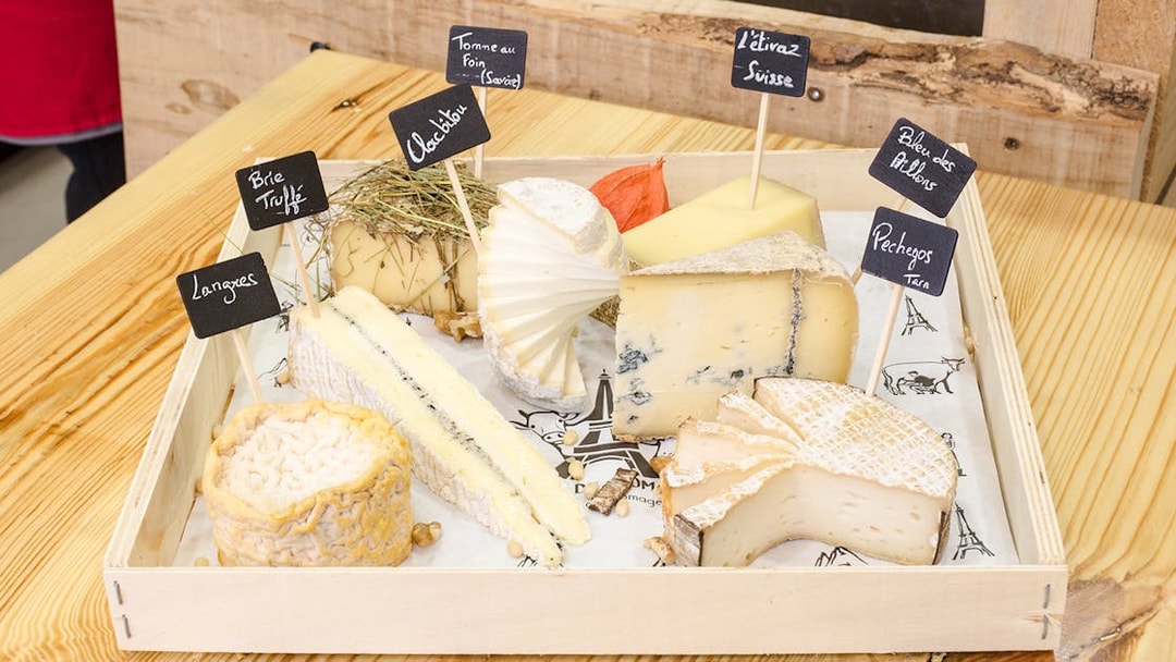 Cheese selection at Cheese Museum Paris, featuring Brie Truffé and Bleu des Causses.