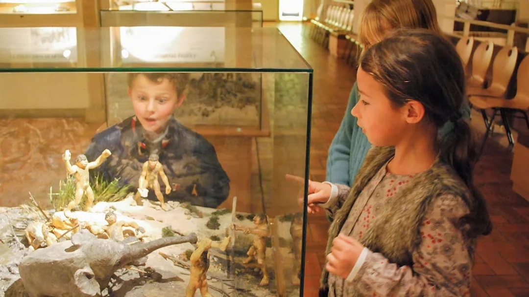 Children observing prehistoric exhibit at French Riviera museum.
