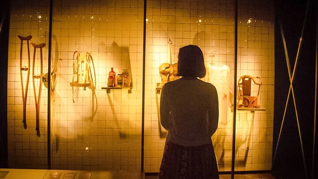 Visitor observing Frida Kahlo's medical artifacts at the Frida Kahlo Museum.