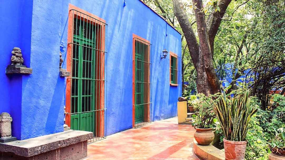 Frida Kahlo Museum exterior with blue walls and garden in Mexico City.