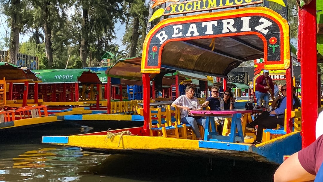 Colorful trajinera boat with tourists on a Xochimilco canal tour in Mexico City.