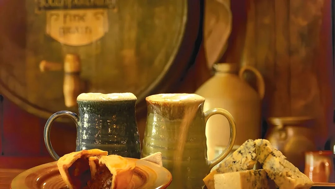 Mugs of ale with pie and cheese at Hobbiton Movie Set, New Zealand.
