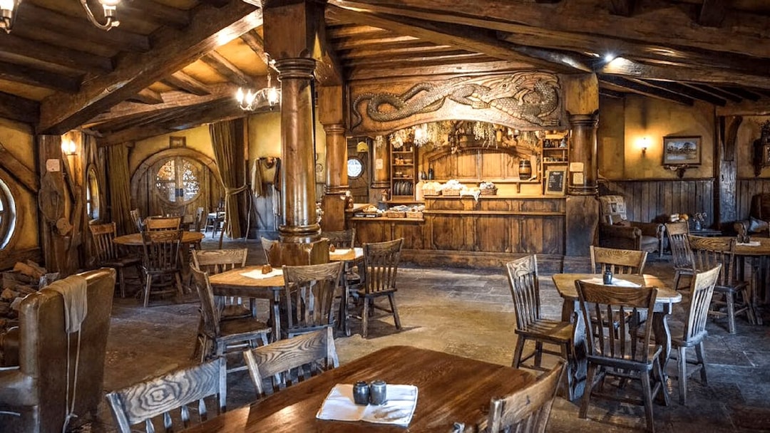 Interior of the Green Dragon Inn at Hobbiton Movie Set with wooden tables and chairs.
