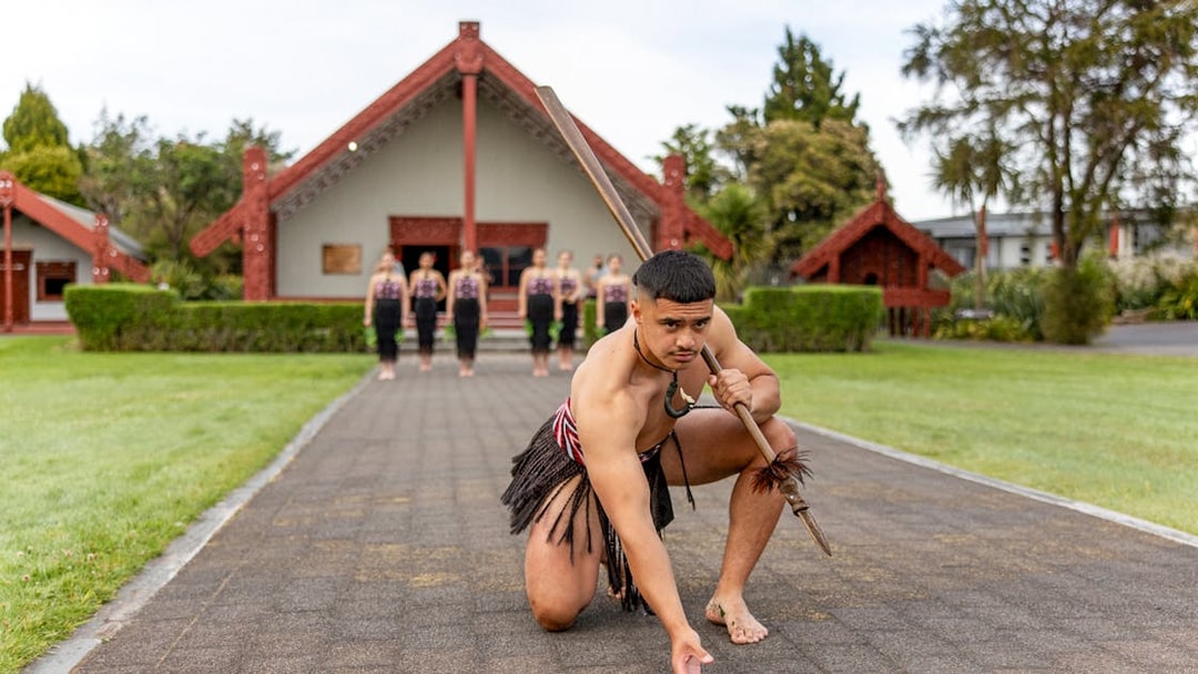 Maori performers in traditional attire performing a haka at Te Puia, Rotorua.