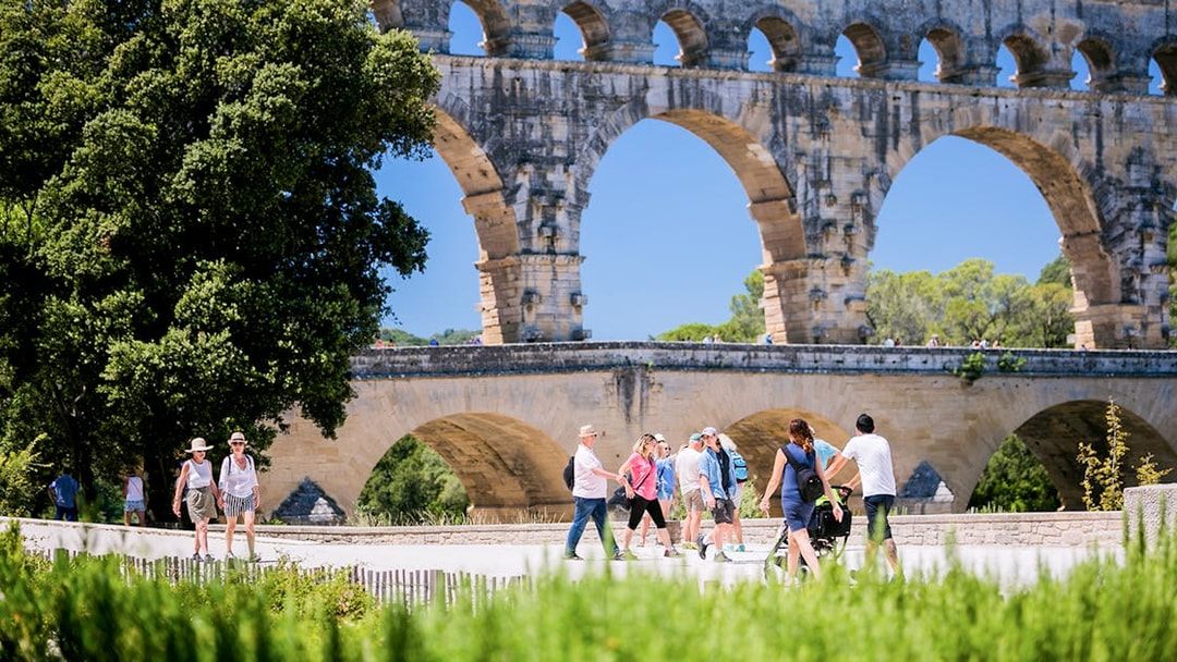 Tourists walking near the Pont du Gard aqueduct in Provence, France.