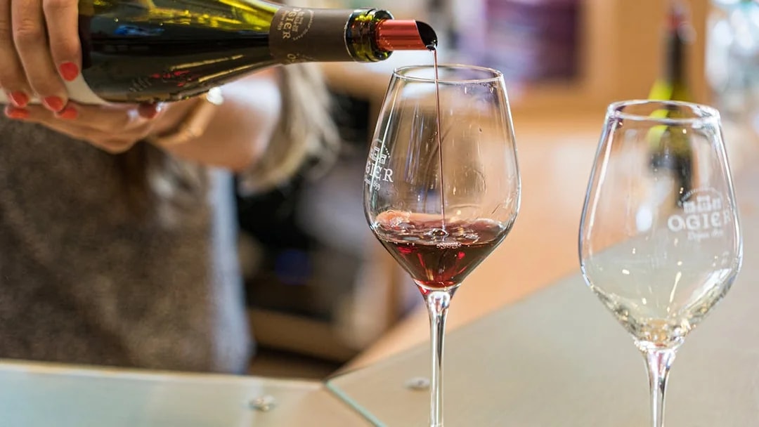 Pouring red wine into a glass during a wine tour in Avignon, France.
