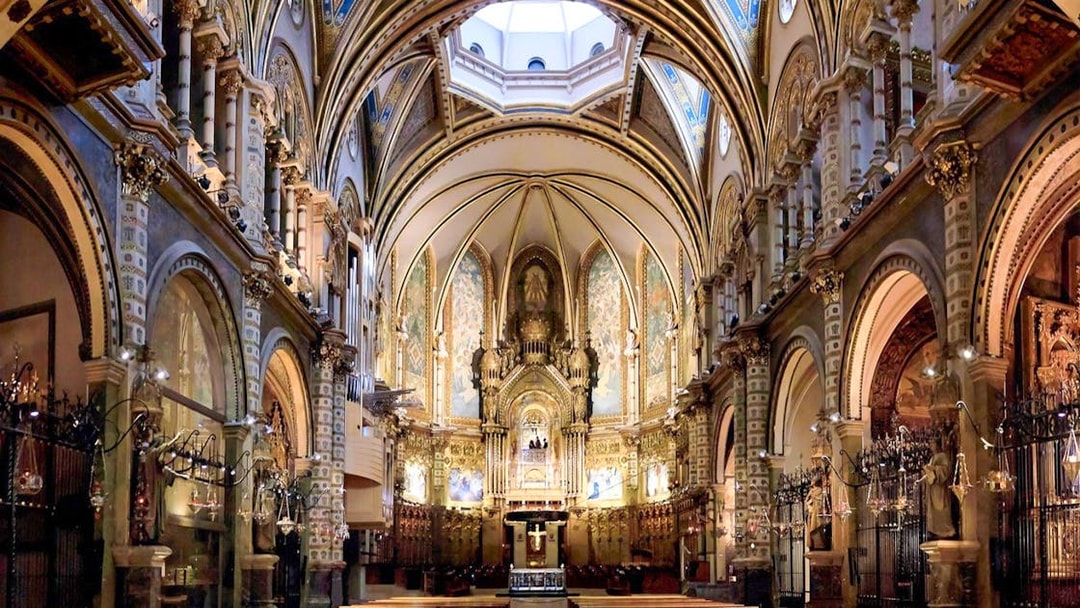 Interior of Montserrat Monastery's basilica with ornate arches and altar, part of Barcelona day trip.