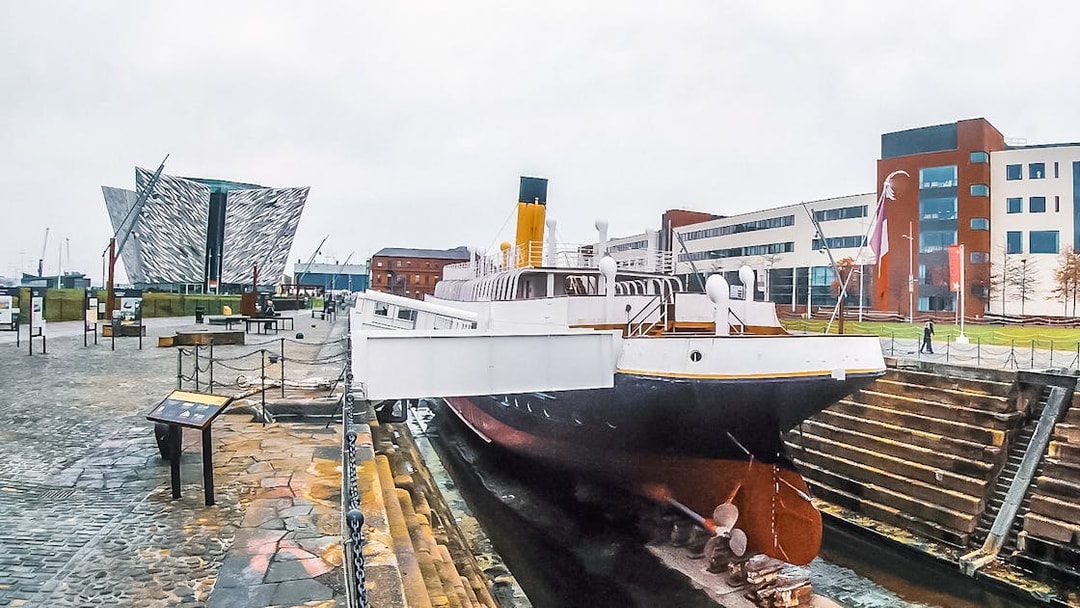 Titanic museum shipyard with historic ship and modern building in Belfast.