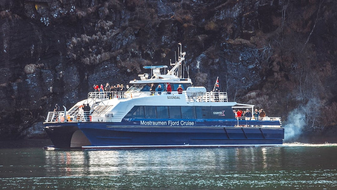 Cruise boat on Mostraumen Fjord near Bergen with passengers on deck.