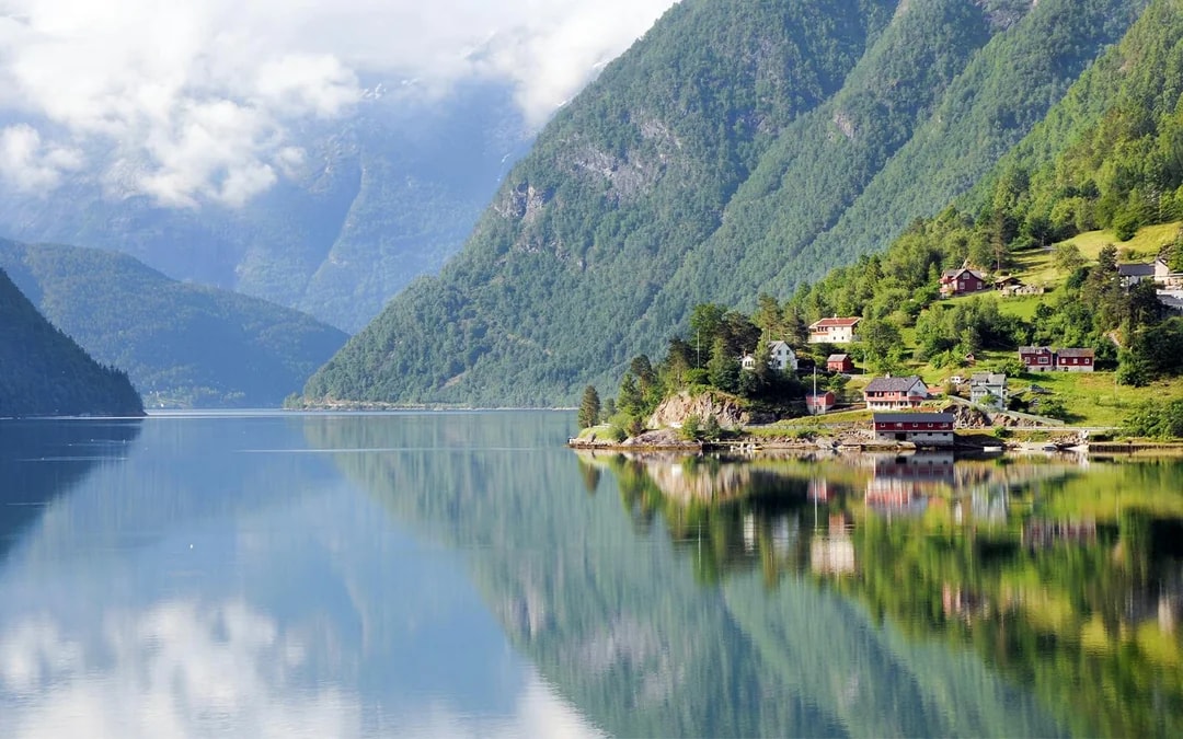 Small villages and mountains along a fjord viewed from a ferry.