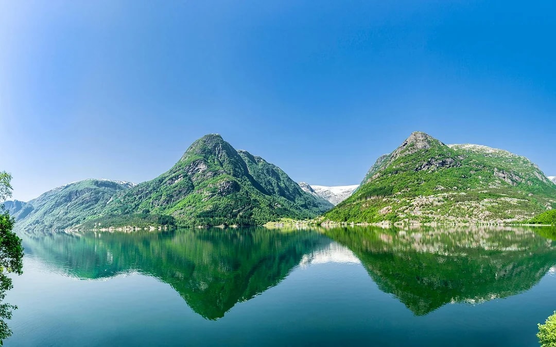 Hardangerfjord view with mountains reflecting in the water, seen from a bus tour in Norway.