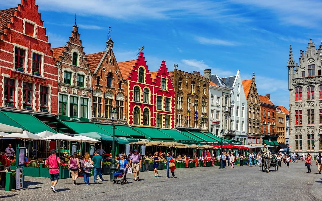 Colorful historic buildings and people in Market Square, Bruges.