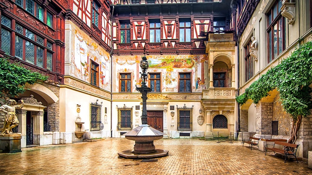 Inner courtyard of Peles Castle with ornate architecture and central fountain.