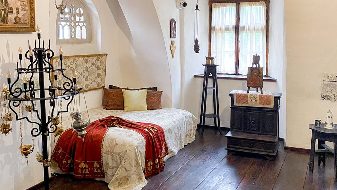 Bran Castle interior, Queen Mary's bedroom with ornate bed and vintage decor, Romania.