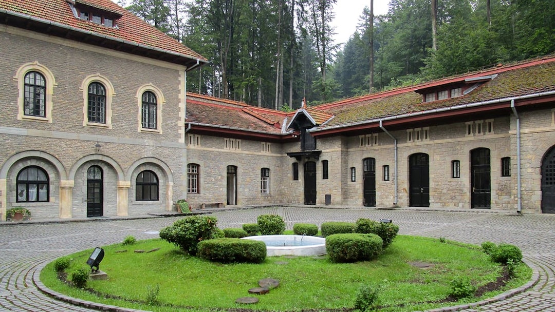 Courtyard view inside Cantacuzino Palace with stone buildings and central garden.