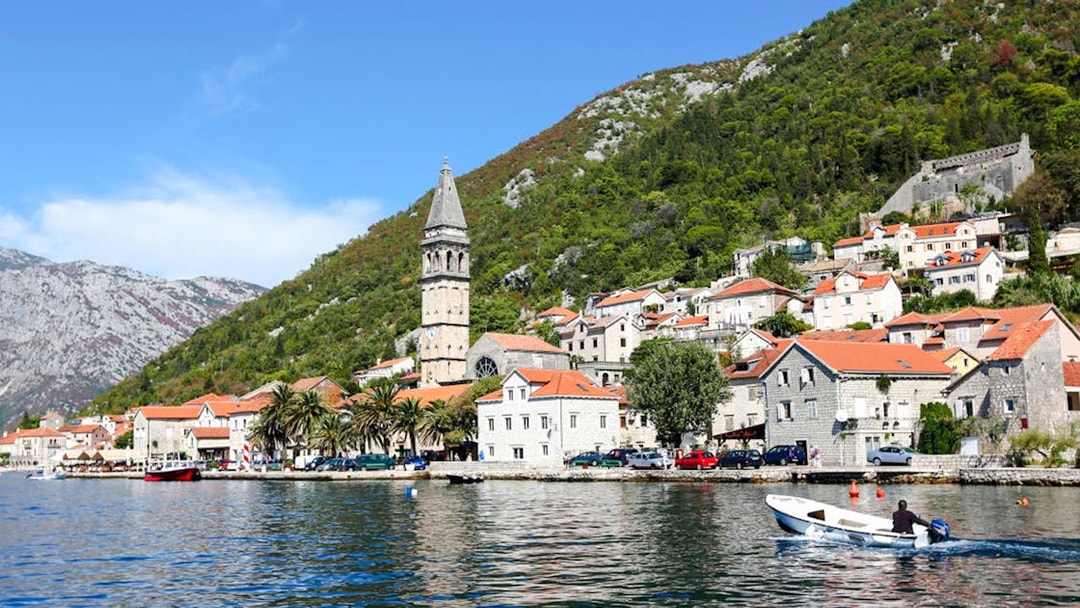 Perast town waterfront with bell tower and boat on the Bay of Kotor.