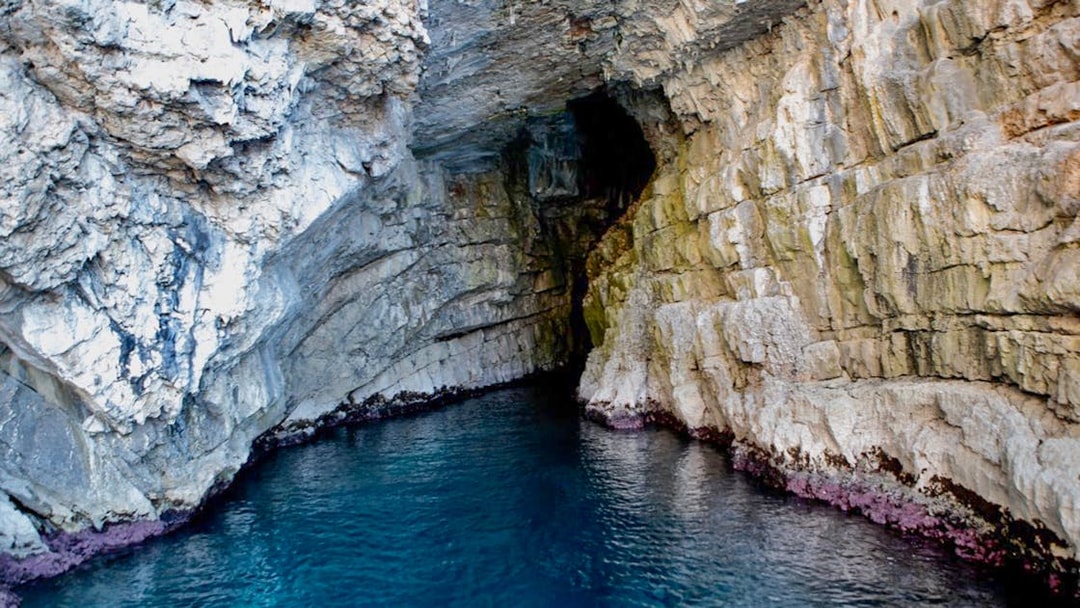 Blue Cave entrance with rocky walls and clear water in Kotor, Montenegro.