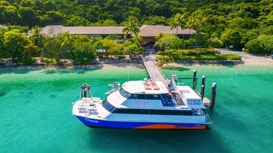 Fitzroy Island ferry docked at lush green island, Cairns day trip.