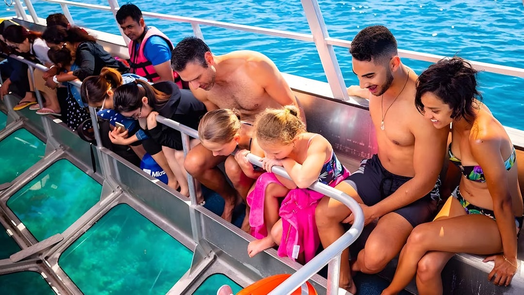 Tourists on a glass-bottom boat viewing Moore Reef, Great Barrier Reef.